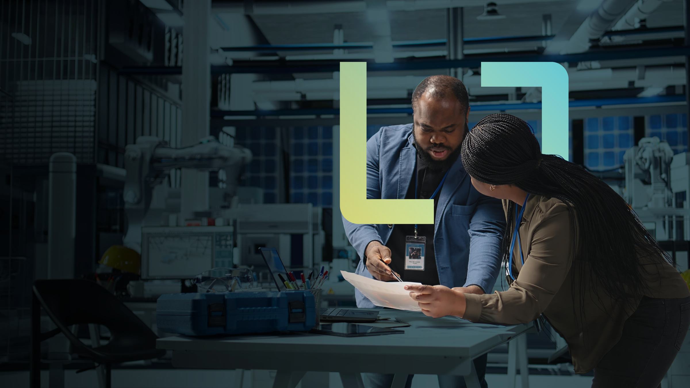 Two colleagues reviewing a document on a production floor